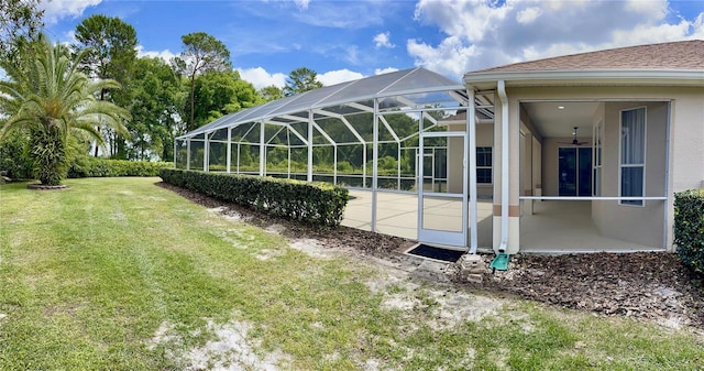 view of yard featuring glass enclosure and a patio