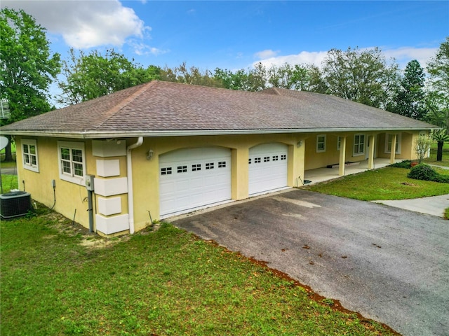 exterior space with a front lawn, a garage, and central AC