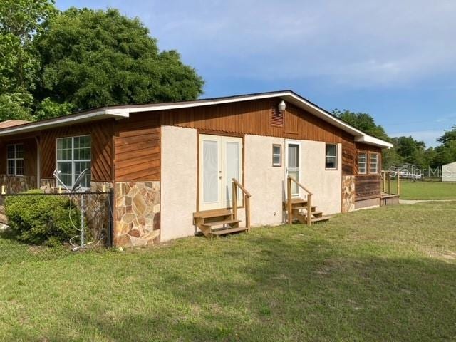 back of house with a lawn