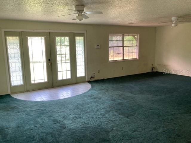 doorway to outside featuring dark colored carpet, a healthy amount of sunlight, and ceiling fan