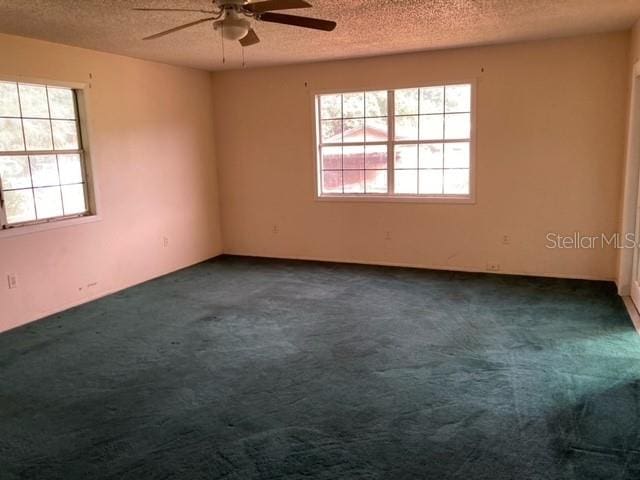 carpeted empty room featuring ceiling fan and a textured ceiling