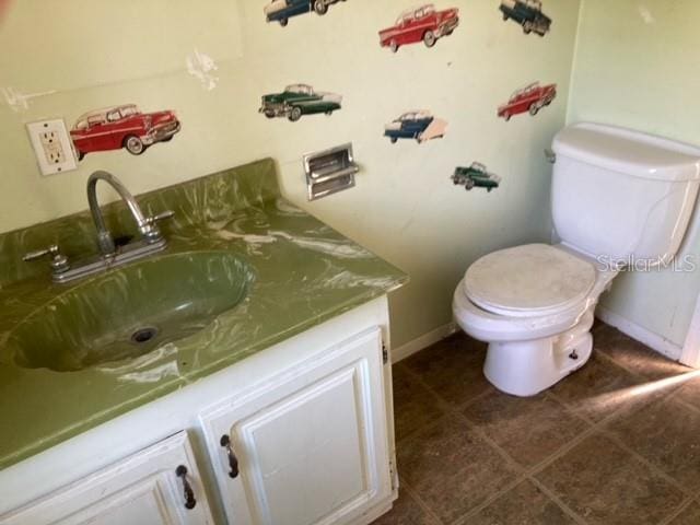 bathroom with vanity, toilet, and tile flooring