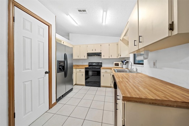 kitchen featuring sink, black range with electric cooktop, light tile flooring, and stainless steel refrigerator with ice dispenser