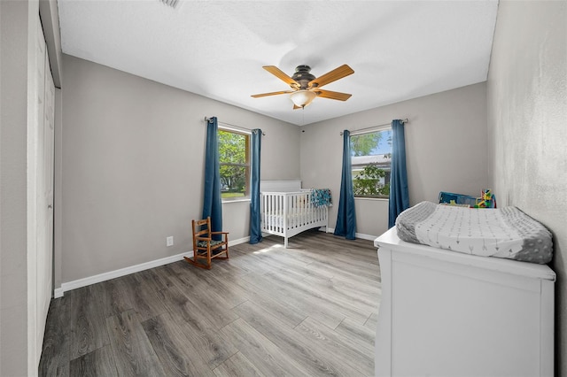 unfurnished bedroom featuring light hardwood / wood-style floors, ceiling fan, and multiple windows