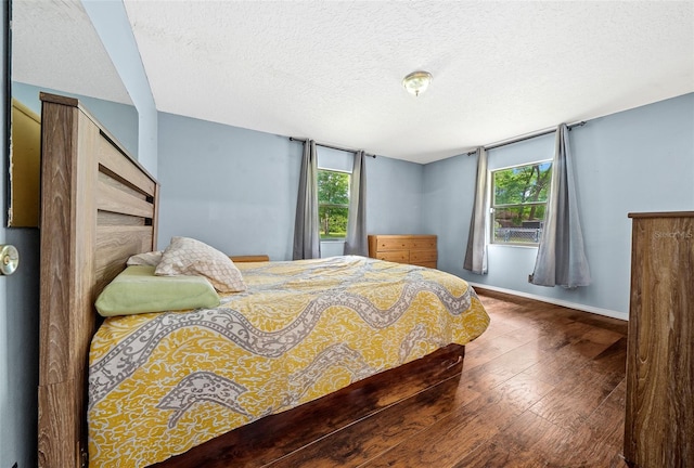 bedroom featuring dark hardwood / wood-style floors and a textured ceiling