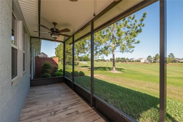 unfurnished sunroom with ceiling fan