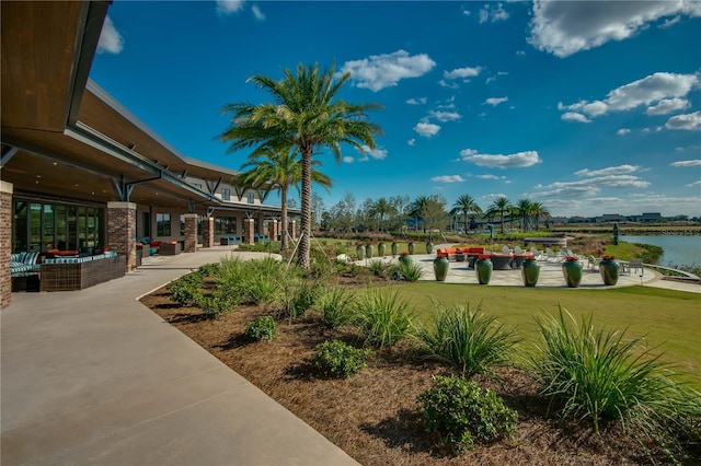 surrounding community featuring a water view, a patio, and a yard