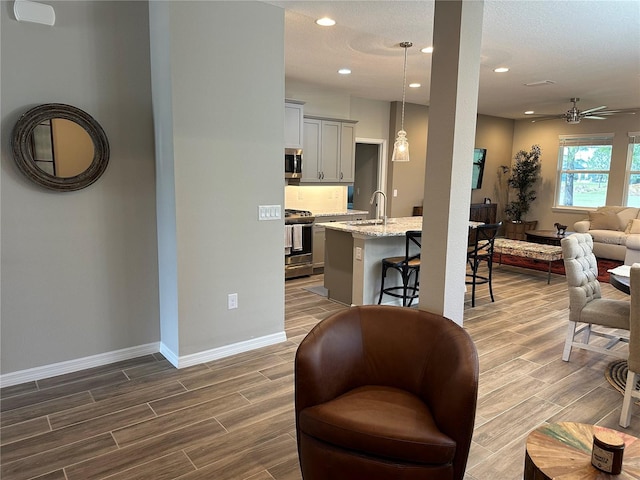 living room with sink, ceiling fan, a textured ceiling, and dark hardwood / wood-style flooring