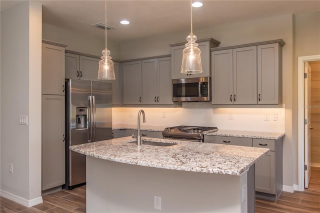 kitchen with light stone countertops, sink, appliances with stainless steel finishes, and dark wood-type flooring