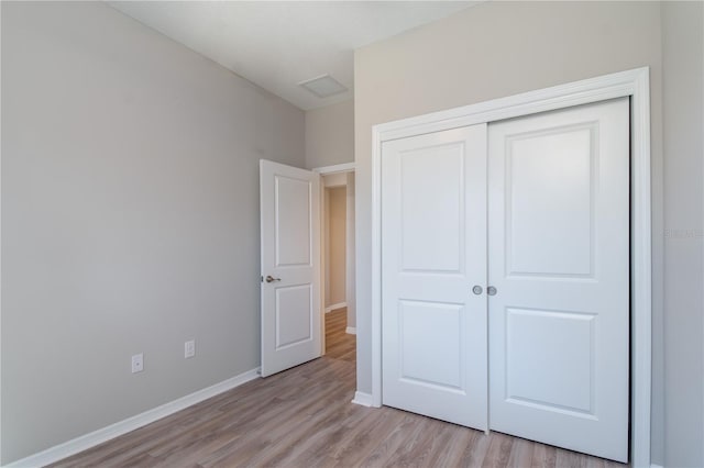 unfurnished bedroom with light hardwood / wood-style floors and a closet