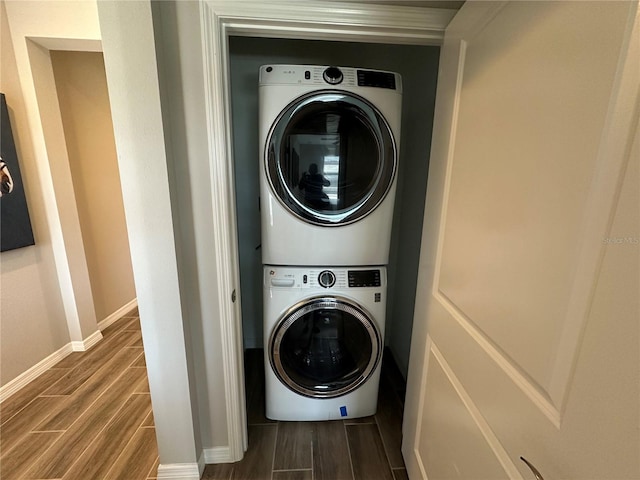 laundry room featuring stacked washing maching and dryer and wood-type flooring