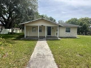 bungalow-style home with covered porch and a front yard