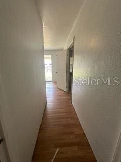 corridor with dark hardwood / wood-style flooring