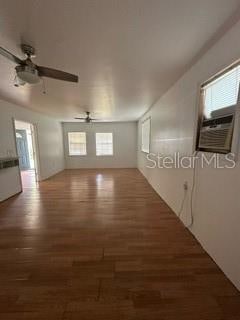 unfurnished living room featuring ceiling fan and dark hardwood / wood-style floors