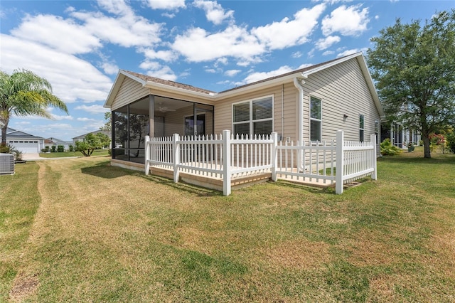 exterior space with central AC, a sunroom, and a yard