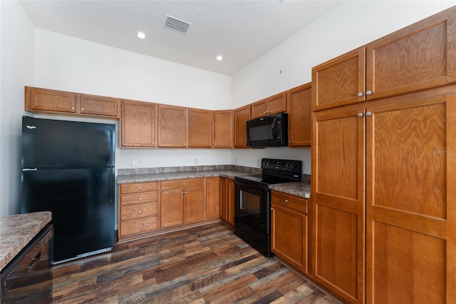 kitchen featuring dark hardwood / wood-style flooring and black appliances