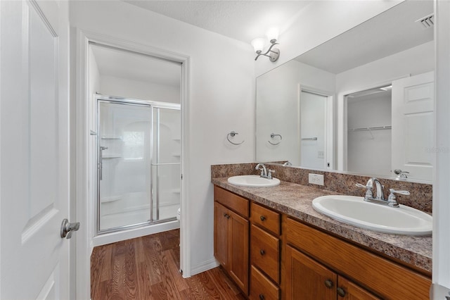 bathroom with vanity, hardwood / wood-style flooring, toilet, a textured ceiling, and an enclosed shower