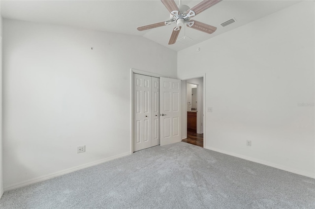 unfurnished bedroom with carpet flooring, a closet, vaulted ceiling, and ceiling fan