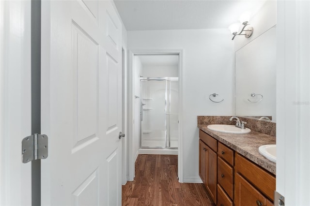 bathroom with hardwood / wood-style floors, vanity, and a shower with shower door