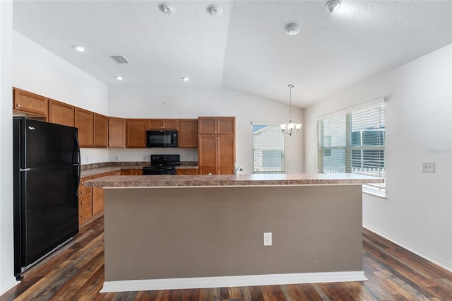 kitchen featuring dark wood-type flooring, black appliances, decorative light fixtures, a kitchen island, and lofted ceiling