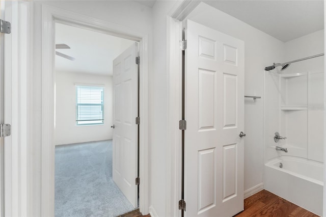 bathroom featuring hardwood / wood-style floors, ceiling fan, and shower / bathtub combination