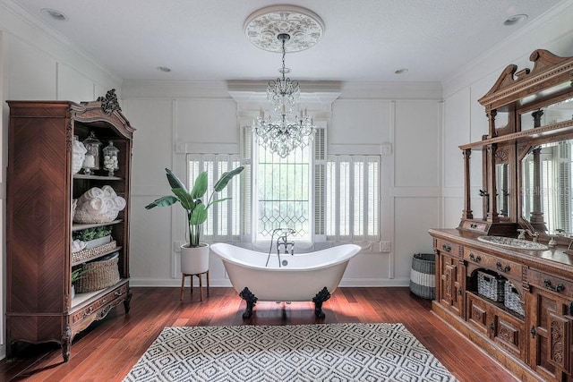 bathroom with hardwood / wood-style floors, a bath, a notable chandelier, and vanity