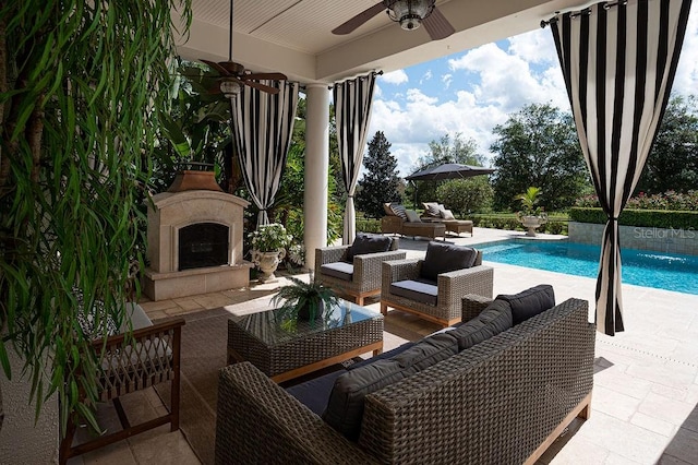 view of patio featuring ceiling fan, a fenced in pool, pool water feature, and an outdoor living space with a fireplace