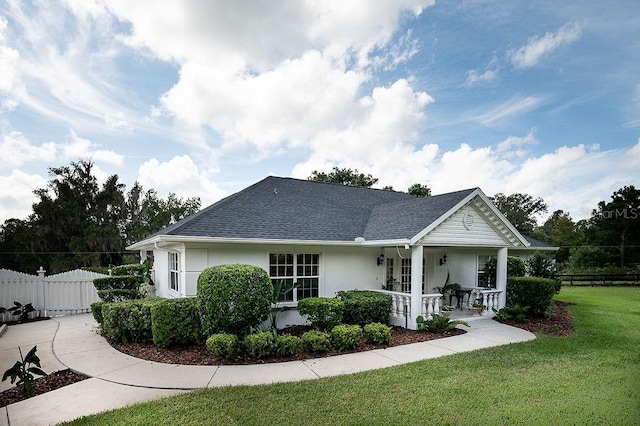 view of front of house with covered porch and a front lawn