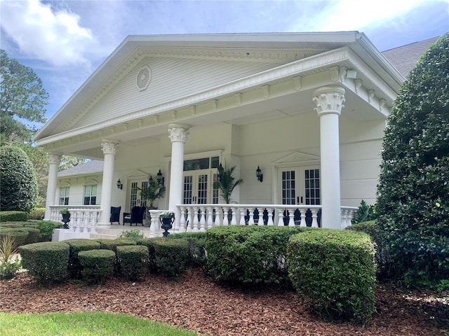 back of property with covered porch and french doors