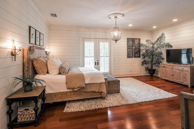 bedroom with wood walls, dark hardwood / wood-style flooring, access to outside, and french doors