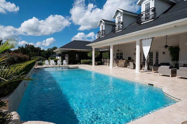 view of pool with an outdoor hangout area, ceiling fan, pool water feature, and a patio