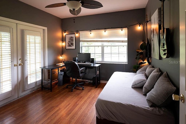 bedroom featuring ceiling fan, hardwood / wood-style floors, french doors, and multiple windows