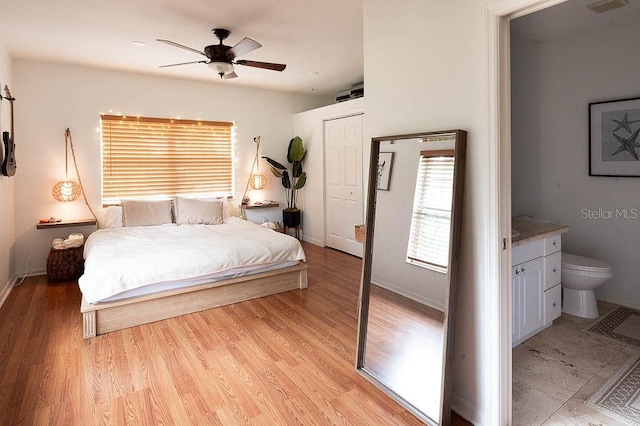 bedroom with ceiling fan, light hardwood / wood-style floors, and ensuite bathroom