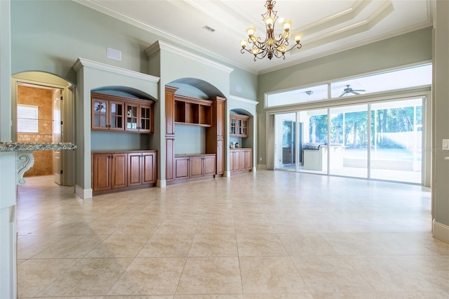 unfurnished living room featuring ceiling fan with notable chandelier, crown molding, a towering ceiling, light tile patterned floors, and a tray ceiling