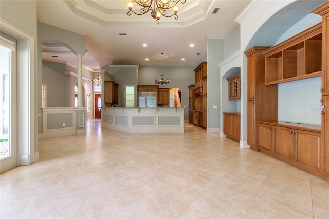 kitchen featuring built in fridge, a notable chandelier, a raised ceiling, and ornamental molding