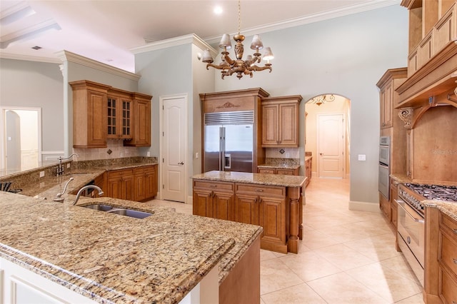 kitchen with appliances with stainless steel finishes, a center island, hanging light fixtures, and sink