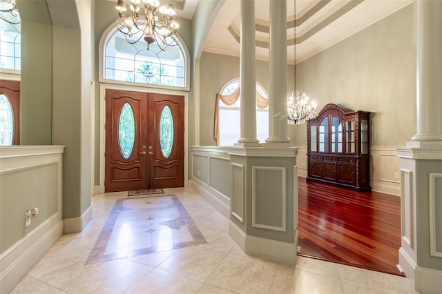 foyer featuring french doors, a high ceiling, and an inviting chandelier