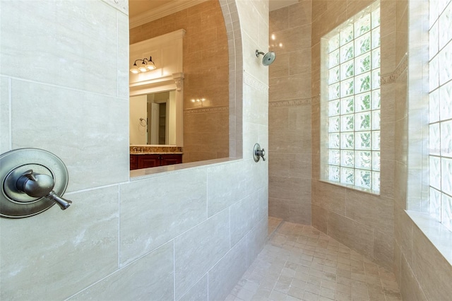 bathroom featuring ornamental molding and tiled shower