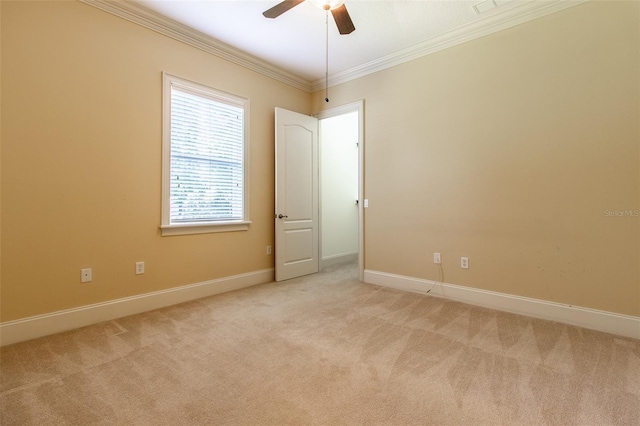 empty room featuring light carpet, ceiling fan, and crown molding