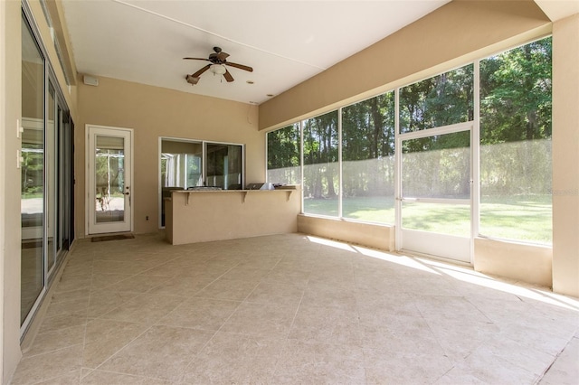 unfurnished sunroom with ceiling fan