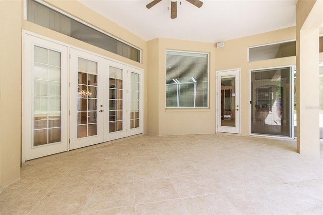 unfurnished sunroom with ceiling fan and french doors