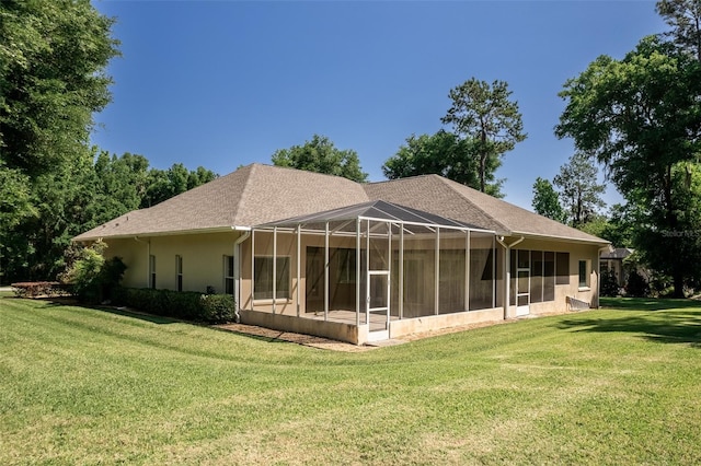 back of house featuring a lawn and a lanai