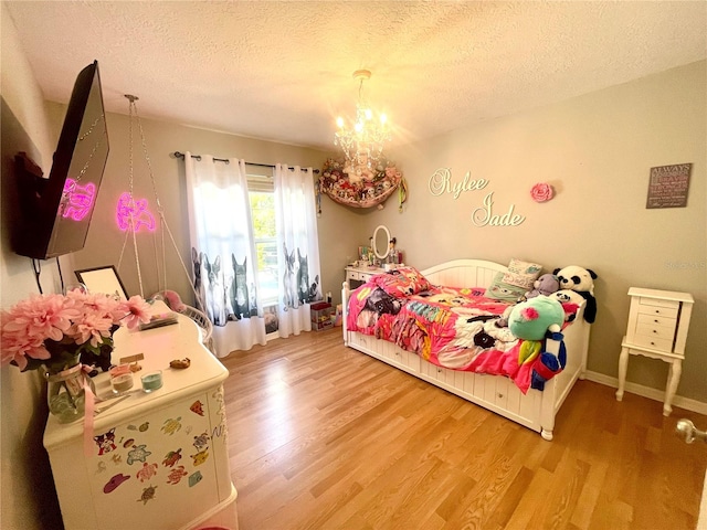 bedroom featuring hardwood / wood-style floors, a notable chandelier, and a textured ceiling