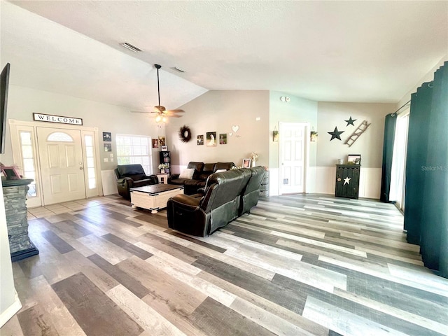 living room with ceiling fan, hardwood / wood-style floors, and lofted ceiling