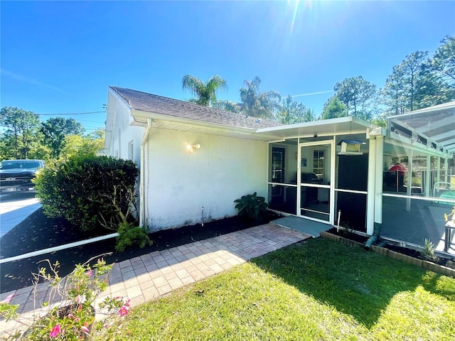 view of front of house featuring a sunroom and a front lawn