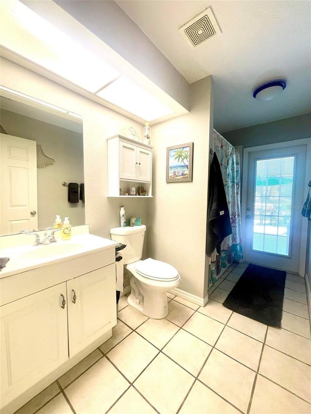 bathroom with tile patterned flooring, vanity, and toilet