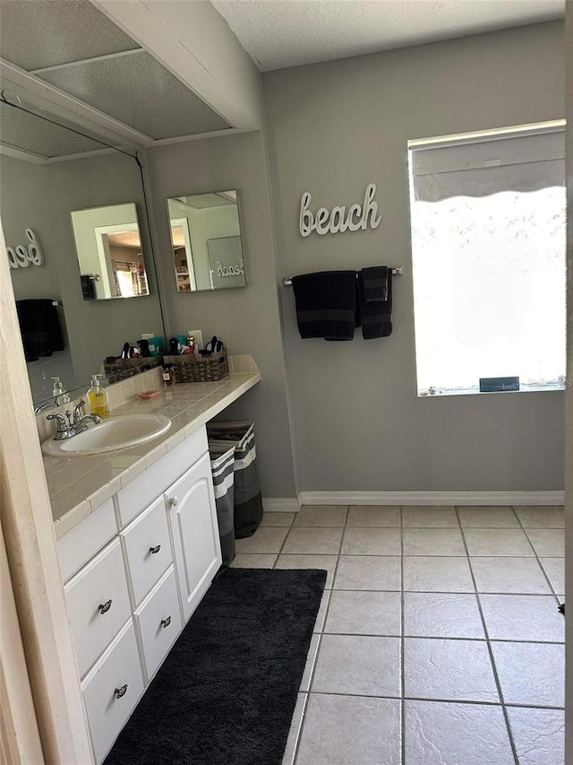 bathroom with tile patterned floors, vanity, and a textured ceiling