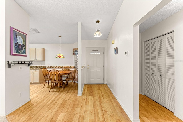 foyer featuring light hardwood / wood-style flooring and a textured ceiling