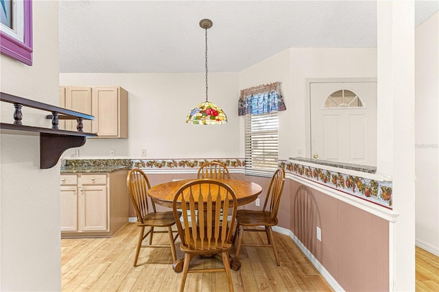 dining area featuring a textured ceiling and light wood-type flooring