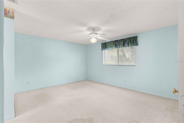 carpeted empty room with ceiling fan and a textured ceiling